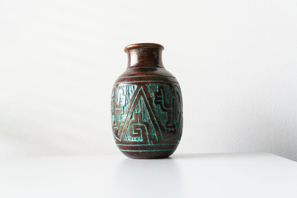 a glass vase with a blue and green design