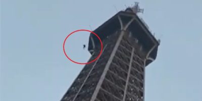 Man beklimt de Eiffeltoren en springt naar beneden, omstanders filmen het