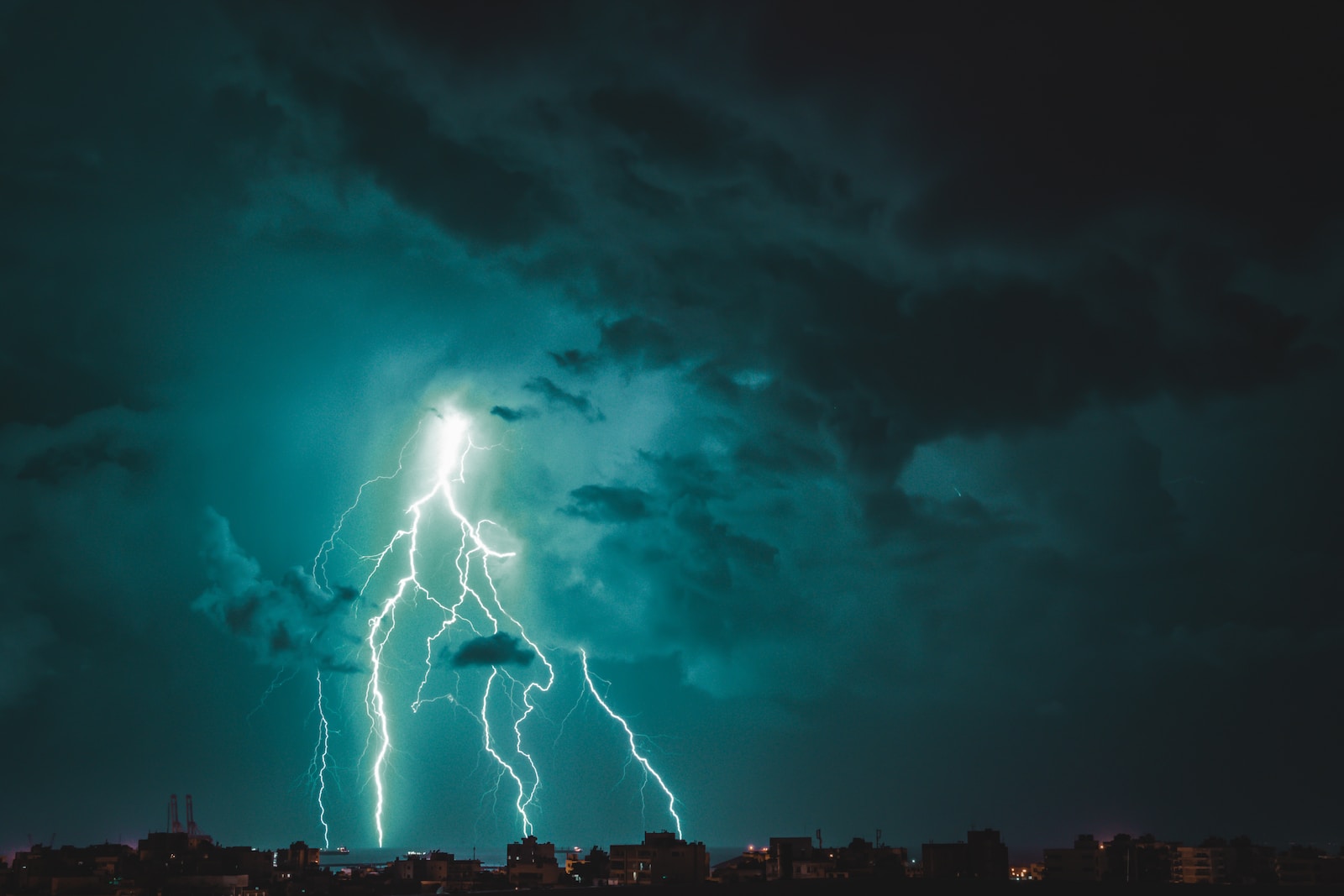 a lightning bolt striking over a city at night